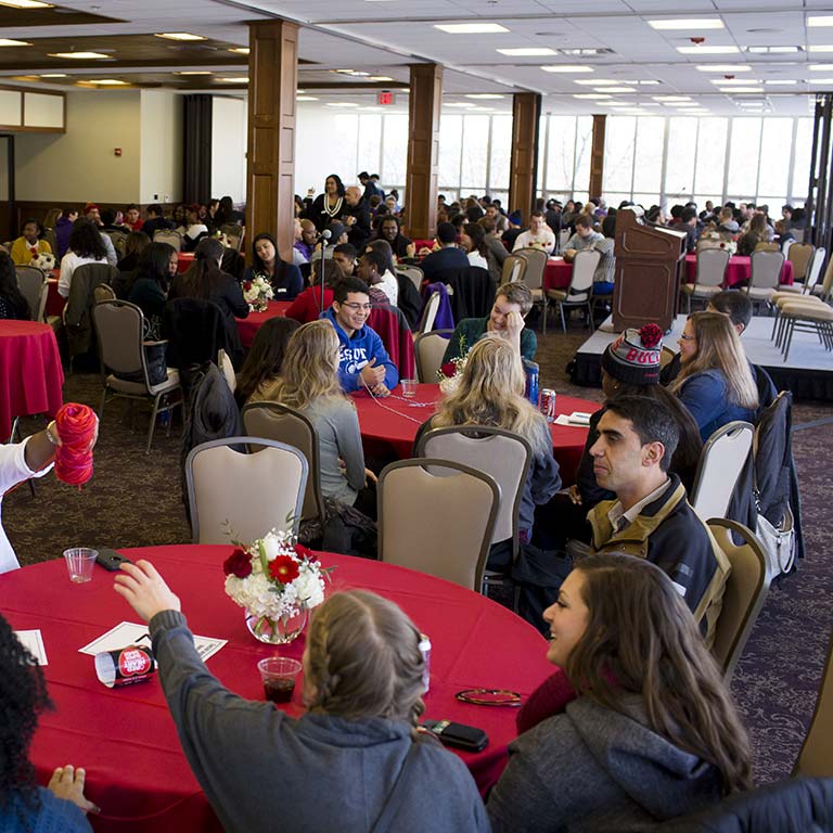 Students sit at tables at an event in the Solarium in the Indiana Memorial Union.