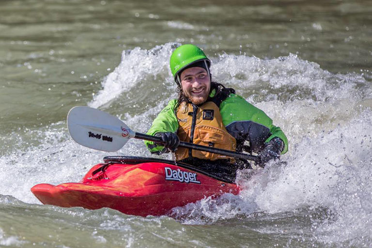 A kayaker paddles through whitewater rapids.