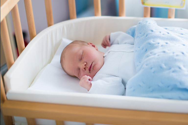 A baby sleeps in a crib.