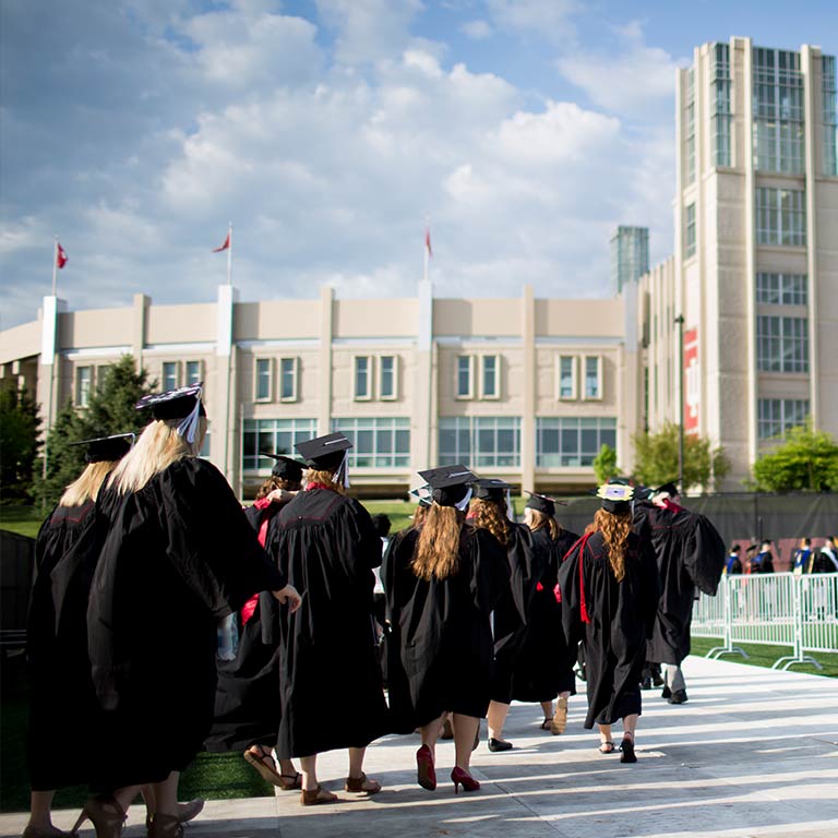 Graduates in caps and gowns walk into Assembly Hall for the Indiana University Commencement ceremony.